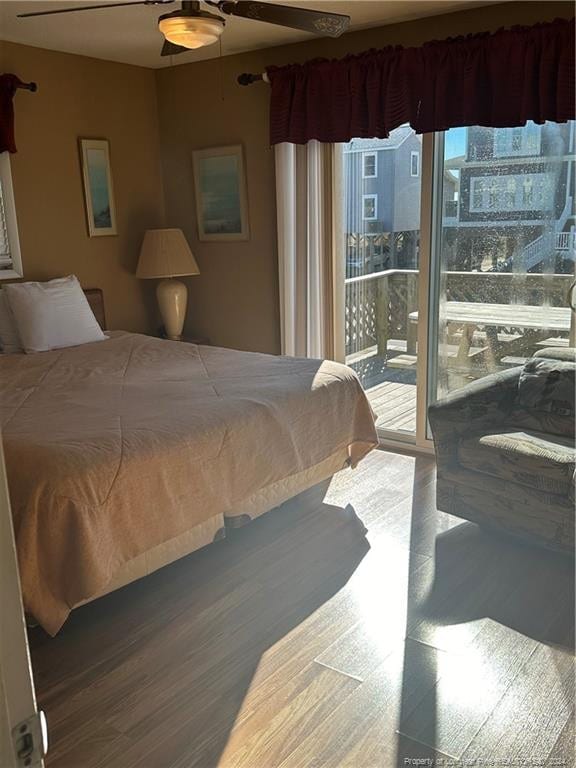 bedroom with ceiling fan, access to exterior, wood-type flooring, and multiple windows