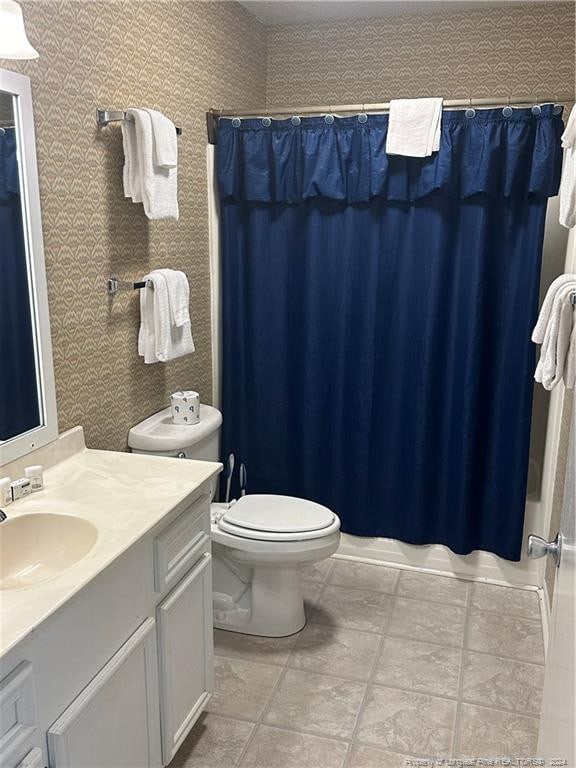 bathroom featuring toilet, vanity, and tile patterned floors