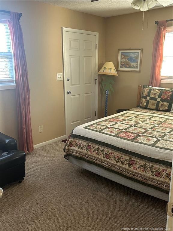 bedroom featuring a textured ceiling, carpet floors, and ceiling fan