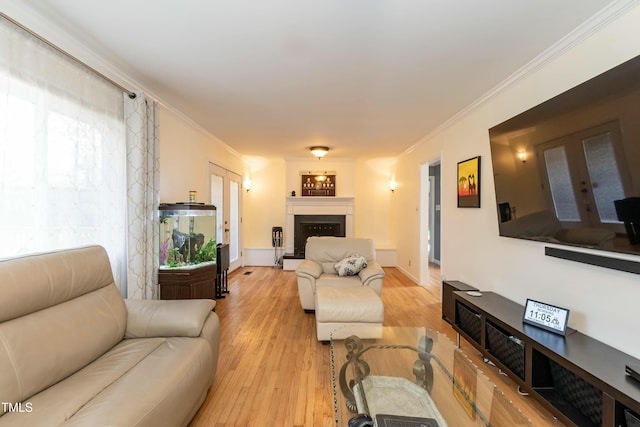 living room with french doors, light wood-type flooring, and crown molding