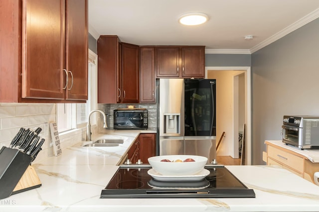 kitchen with sink, tasteful backsplash, light stone counters, stainless steel refrigerator with ice dispenser, and crown molding