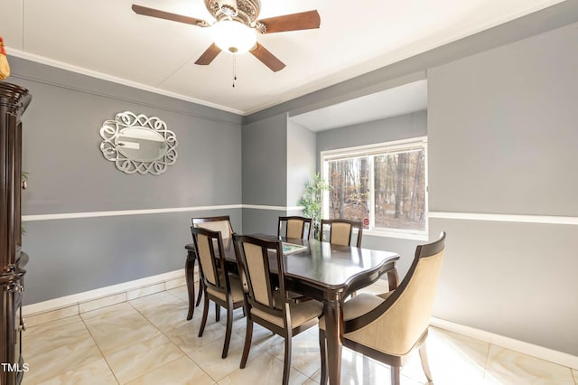 dining space with ceiling fan and ornamental molding