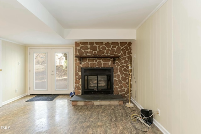 unfurnished living room with a stone fireplace, french doors, wood-type flooring, and ornamental molding