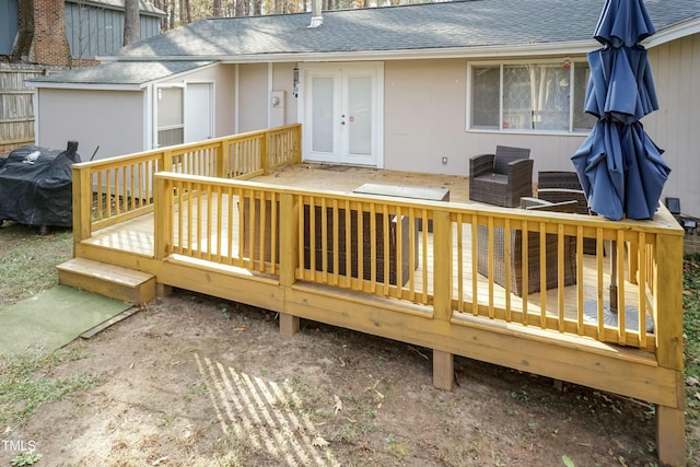 wooden deck with french doors, an outdoor living space, and area for grilling