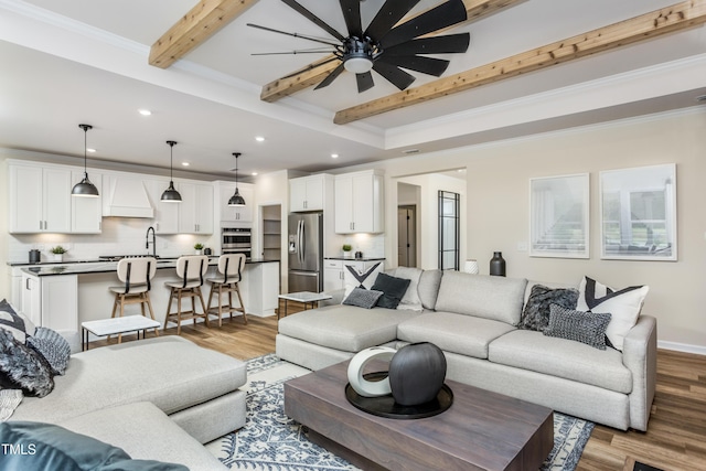 living room with beamed ceiling, light hardwood / wood-style flooring, ceiling fan, and ornamental molding