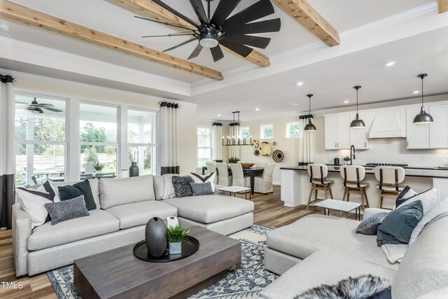 living room with ceiling fan with notable chandelier, hardwood / wood-style flooring, and crown molding