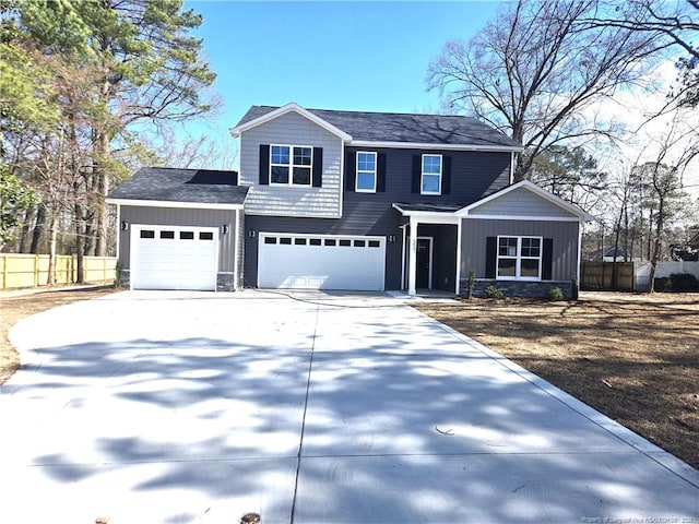 traditional-style home featuring an attached garage, board and batten siding, fence, and concrete driveway