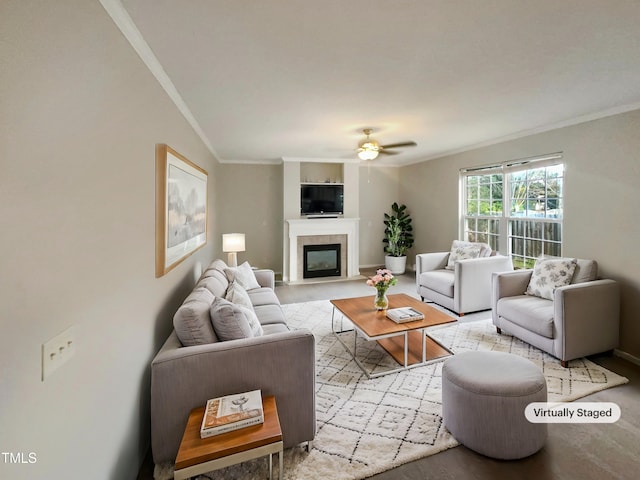 living room featuring ceiling fan, crown molding, a fireplace, and vaulted ceiling