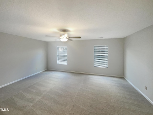 unfurnished room with light colored carpet and a textured ceiling