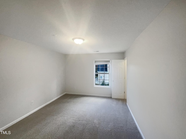 unfurnished room with carpet and a textured ceiling