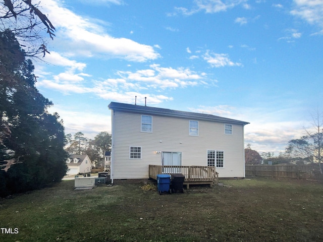 rear view of house with a deck and a yard