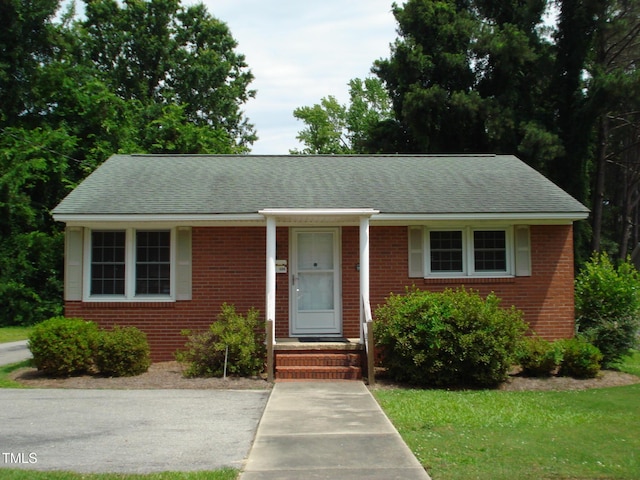 608 N Ellis Ave, Dunn, NC 28334 - view of front of home with brick siding, a shingled roof, and a front yard