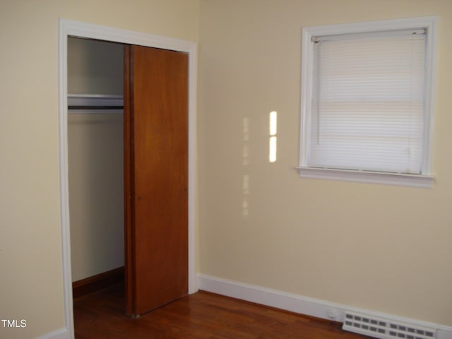 unfurnished bedroom featuring dark hardwood / wood-style flooring and a closet