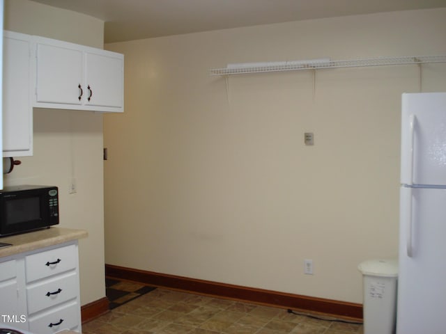 kitchen featuring white cabinetry and white refrigerator