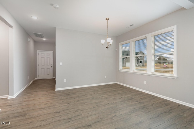 unfurnished room featuring a chandelier and dark hardwood / wood-style flooring