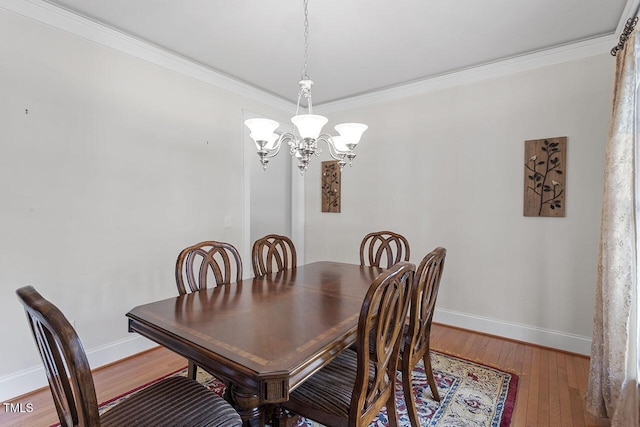 dining room with baseboards, a chandelier, wood finished floors, and ornamental molding