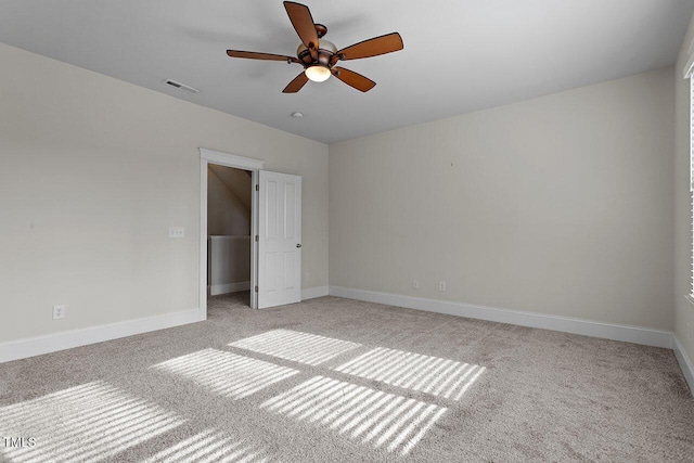 unfurnished bedroom featuring baseboards, a ceiling fan, visible vents, and light colored carpet