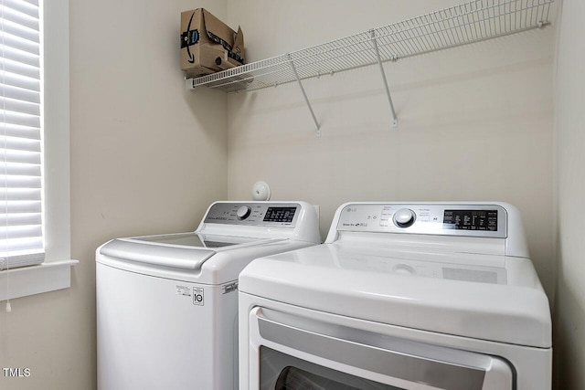 clothes washing area featuring laundry area and washer and clothes dryer