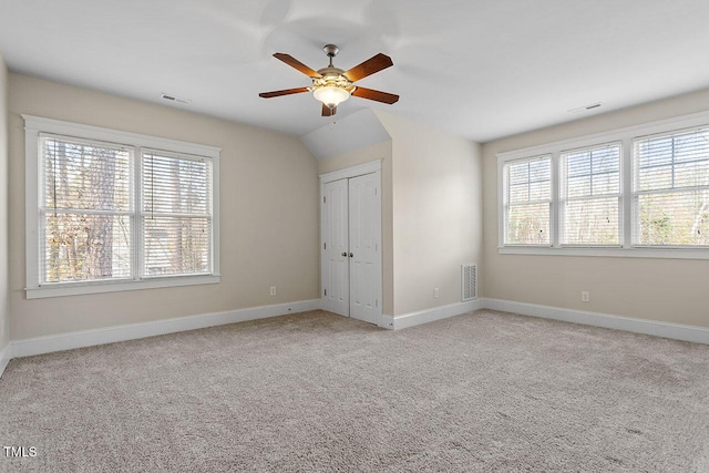 unfurnished bedroom with light carpet, multiple windows, and visible vents