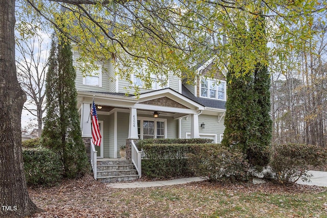 view of front of home with a porch and roof with shingles