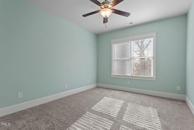 spare room featuring light carpet, baseboards, visible vents, and ceiling fan