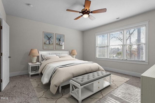 bedroom featuring light carpet, visible vents, baseboards, and ceiling fan