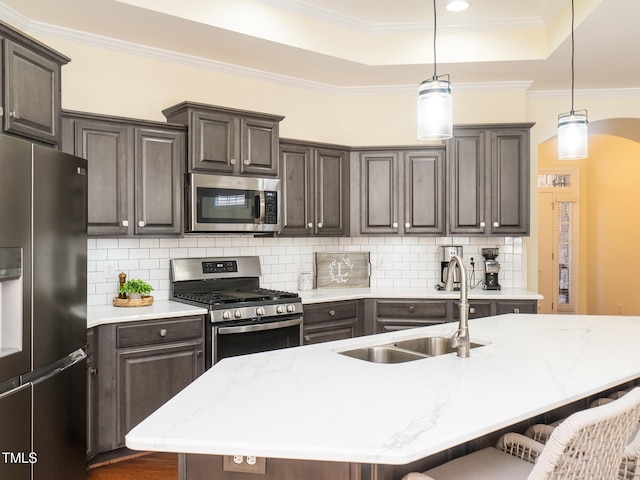 kitchen featuring appliances with stainless steel finishes, a kitchen breakfast bar, ornamental molding, sink, and pendant lighting