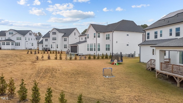 view of yard with a trampoline and central AC