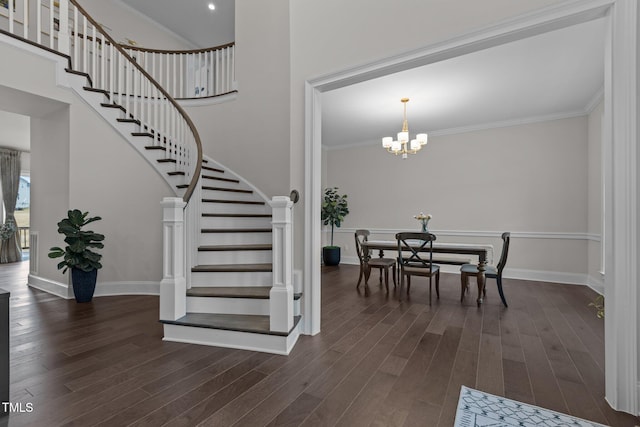 staircase with wood-type flooring, crown molding, and a notable chandelier