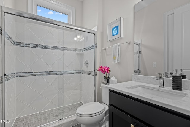 bathroom featuring vanity, an enclosed shower, and toilet