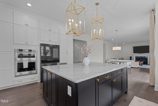 kitchen featuring double oven, white cabinetry, dark hardwood / wood-style floors, and decorative light fixtures