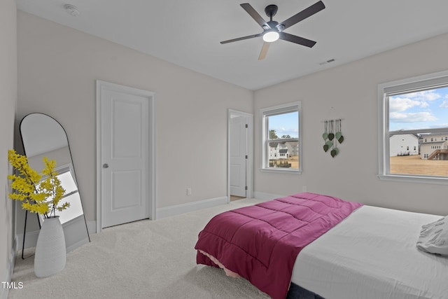 carpeted bedroom featuring ceiling fan and multiple windows