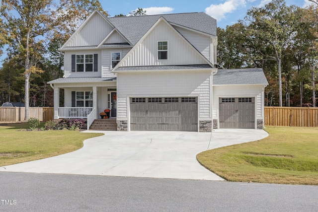 view of front of property with a garage, a front lawn, and a porch