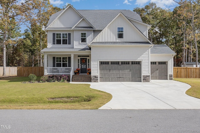 view of front of house with a garage, a front lawn, and covered porch