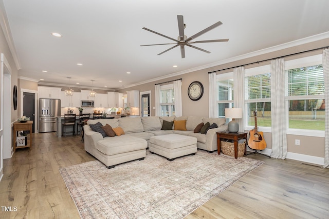 living room featuring crown molding, ceiling fan, and light hardwood / wood-style floors