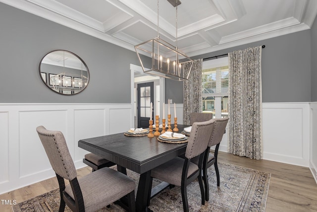 dining space with coffered ceiling, hardwood / wood-style floors, and a notable chandelier