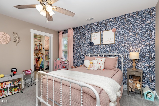 carpeted bedroom featuring ceiling fan and a spacious closet