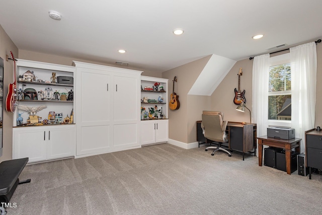 carpeted home office with vaulted ceiling