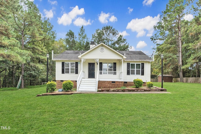 view of front of house with covered porch, a shed, and a front yard