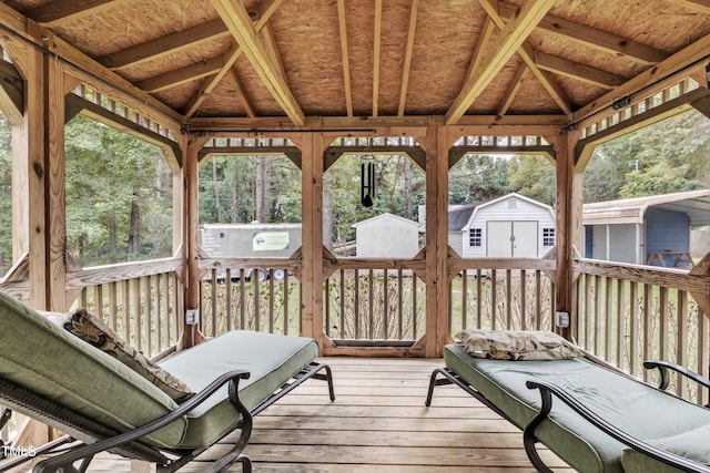 wooden deck with a gazebo, a hot tub, and a storage shed