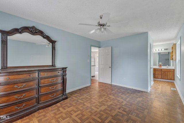 bedroom with ensuite bathroom, ceiling fan, dark parquet flooring, and sink