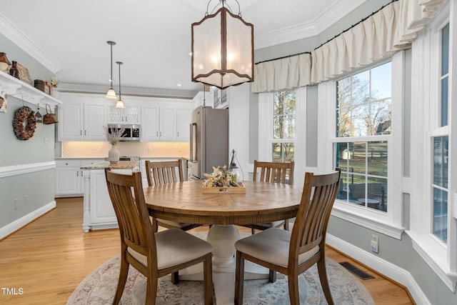 4027 Green Forest Ct, Rocky Mount, NC 27804 - dining space with a wealth of natural light, crown molding, and light hardwood / wood-style floors