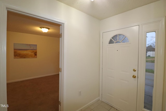 entrance foyer featuring light tile patterned floors and a textured ceiling