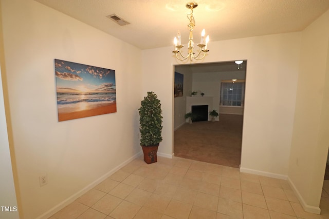 corridor featuring light tile patterned floors and a chandelier