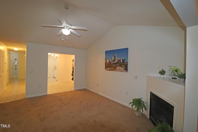 living room featuring ceiling fan with notable chandelier, light colored carpet, and lofted ceiling