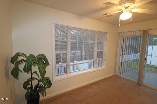 carpeted spare room featuring ceiling fan