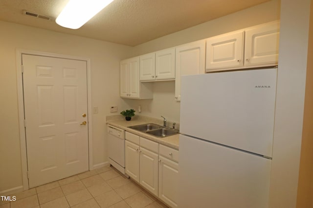 kitchen featuring white appliances, white cabinets, sink, a textured ceiling, and light tile patterned flooring