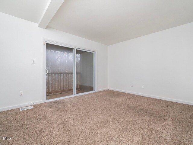 unfurnished room featuring beamed ceiling and carpet