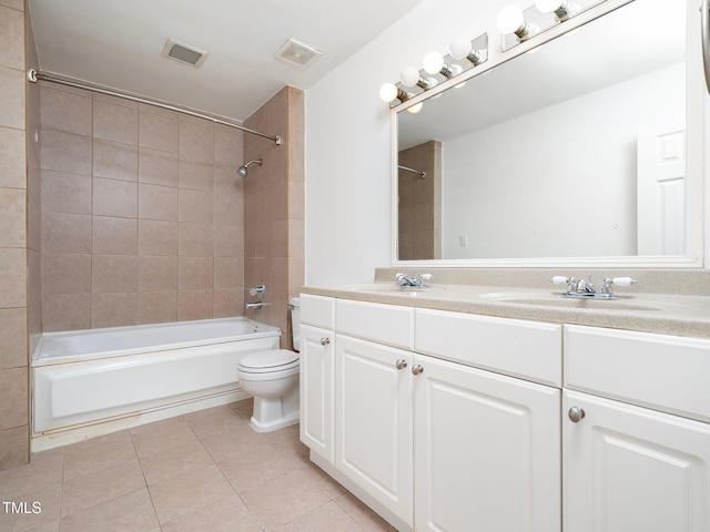 full bathroom with tile patterned floors, toilet, tiled shower / bath combo, and vanity