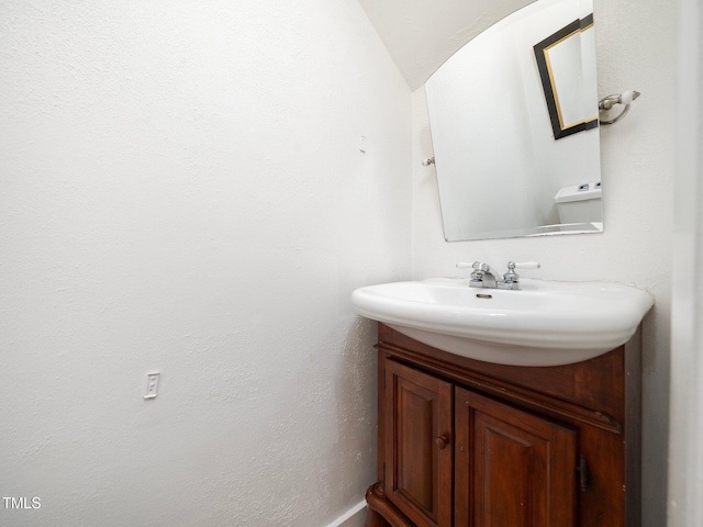 bathroom with vaulted ceiling and vanity